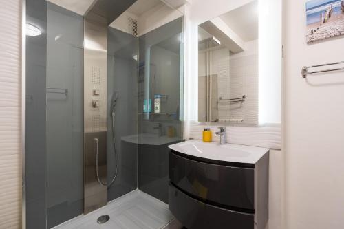 une salle de bain avec un lavabo et une douche dans l'établissement Bright & Contemporary 2BD Apartment, à Paris