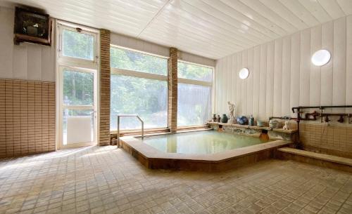 a large bathroom with a large tub in a room at Shirokane Freeport Hotel - Vacation STAY 85764 in Kami-furano