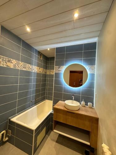 une salle de bain avec un lavabo, une baignoire et un miroir dans l'établissement Appartement chaleureux à Uvernet-Fours, 48m², vue montagne, à Uvernet