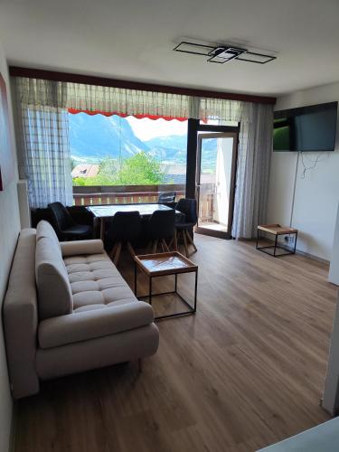 a living room with a couch and a large window at Ferienwohnung - Apartment Pichlarn Holiday Grimmingblick in Aigen im Ennstal