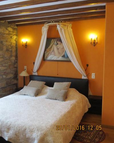 a bedroom with a bed with a painting on the wall at B&B Nord Sud in Salmchâteau