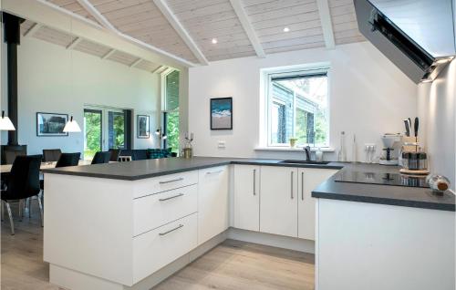 a kitchen with white cabinets and a black counter top at Stunning Home In Hjørring With Wifi in Hjørring