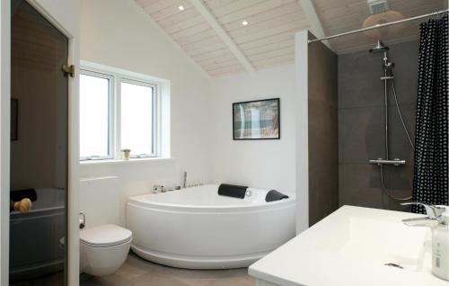 a white bathroom with a tub and a toilet at Stunning Home In Hjørring With Wifi in Hjørring