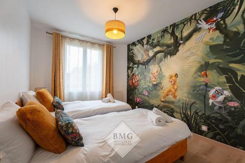Dos camas en una habitación con un mural en la pared. en Villa Debussy Disneyland, en Bussy-Saint-Georges