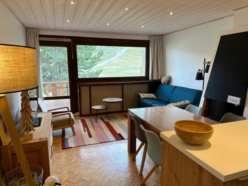 un salon avec un canapé bleu et une table dans l'établissement Appartement chaleureux à Uvernet-Fours, 48m², vue montagne, à Uvernet