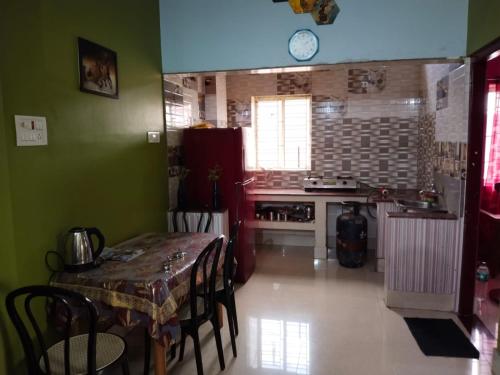 a kitchen with a table and a kitchen with a stove at Veda Home's in Agartala