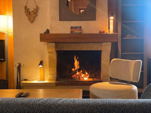 une cheminée dans un salon avec un feu dans l'établissement Chalet Aster, à Germ