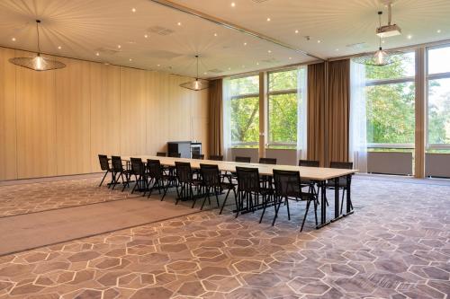 a large conference room with a long table and chairs at Leonardo Royal Hotel Köln - Am Stadtwald in Cologne