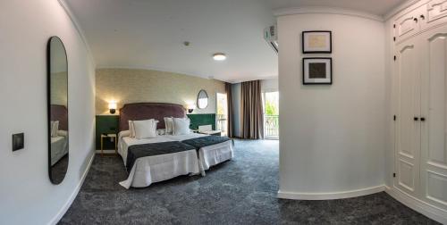 a hotel room with a bed and a balcony at Hotel Tamisa Golf in Mijas