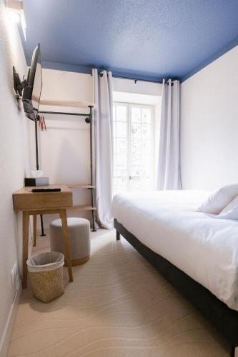 a bedroom with a bed and a desk and a window at La Bastide de Montferrat in Montferrat
