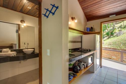 a kitchen with a sink and a stove top oven at Pousada dos Ingleses in Bombinhas