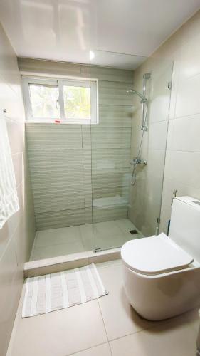 a bathroom with a glass shower and a toilet at Blue Skies on endless Beachfront in Cabarete
