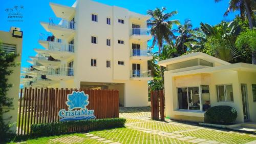 a building with a fence in front of it at Blue Skies on endless Beachfront in Cabarete