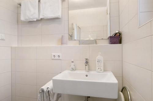 a white bathroom with a sink and a mirror at Pension Zum Talhof in Reichenau