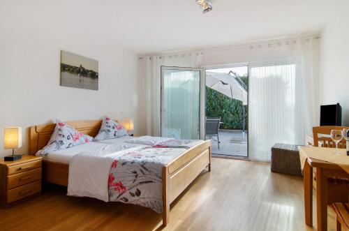 a bedroom with a bed and a sliding glass door at Pension Zum Talhof in Reichenau