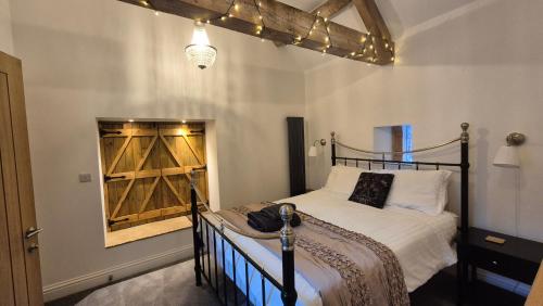 a bedroom with a bed with a wooden head board at Pear Tree Barns in Rangeworthy
