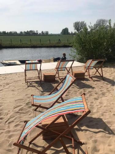 a group of chairs sitting on a sandy beach at Dobberhuisje in IJsselstein
