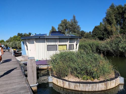 a building on a dock next to a body of water at Dobberhuisje in IJsselstein