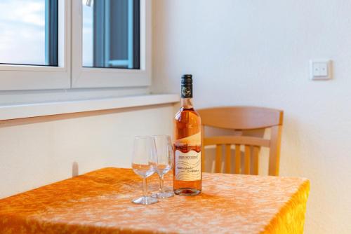 a bottle of wine sitting on a table with two glasses at Pension Zum Talhof in Reichenau