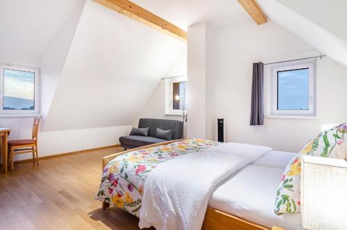a bedroom with a bed and a chair at Pension Zum Talhof in Reichenau