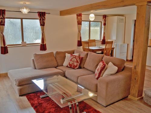 a living room with a couch and a table at Dove Cottage in Ampney Crucis