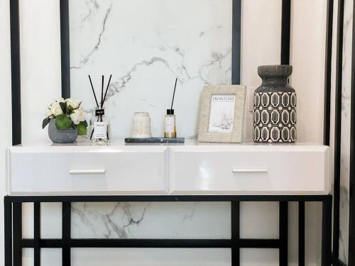 a white shelf with a vase and flowers on it at The Jeewel of La Casa IV in Surabaya