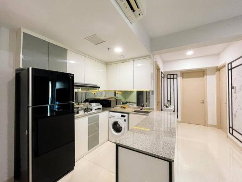 a kitchen with a black refrigerator and a dishwasher at The Jeewel of La Casa IV in Surabaya