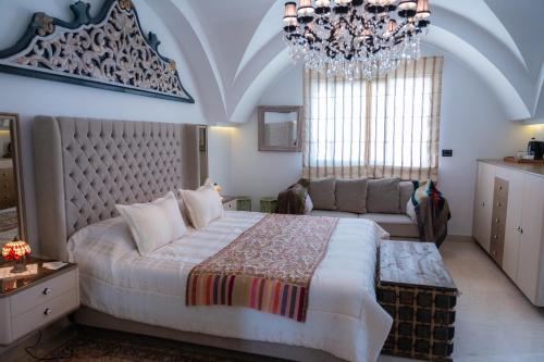 a bedroom with a large bed and a chandelier at Dar Al Makam - Luxury Experience in Soliman