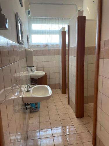 łazienka z 2 umywalkami i oknem w obiekcie la casa di Frinky w mieście Ponte Galeria