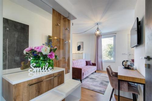 a living room with a vase of flowers on a counter at Duna P'Art Panzió in Verőce