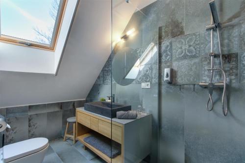 a bathroom with a glass shower and a toilet at Duna P'Art Panzió in Verőce