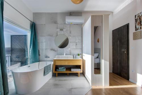 a bathroom with a large tub and a sink at Duna P'Art Panzió in Verőce
