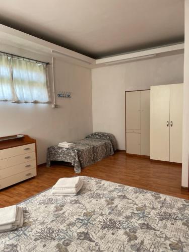 a bedroom with two beds and a dresser and a window at la casa di Frinky in Ponte Galeria