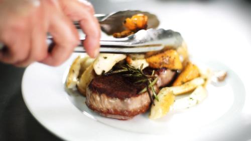 a person holding a fork and a plate of food at Gut Hügle Erlebnishof in Ravensburg