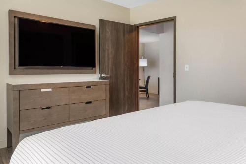 a bedroom with a bed and a flat screen tv at Cambria Hotel St Petersburg-Madeira Beach Marina in St Pete Beach