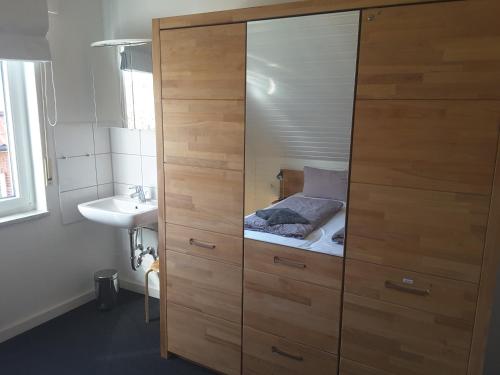 a large wooden cabinet with a bed in it in a bathroom at Deichblick Süderloog 38 in Spiekeroog