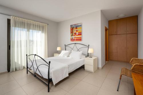 a bedroom with a large bed with white pillows at Gonos Villas in Asklipiḯon