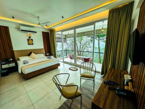 a bedroom with a bed and a table and chairs at Boulevard Resorts in Kakkadampoyil