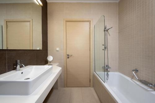 a bathroom with a sink and a tub and a shower at Gonos Villas in Asklipiḯon