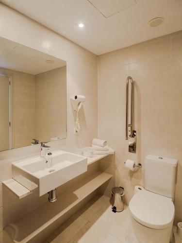 a bathroom with a sink and a toilet and a mirror at Hotel La Santa Maria in Cala Millor