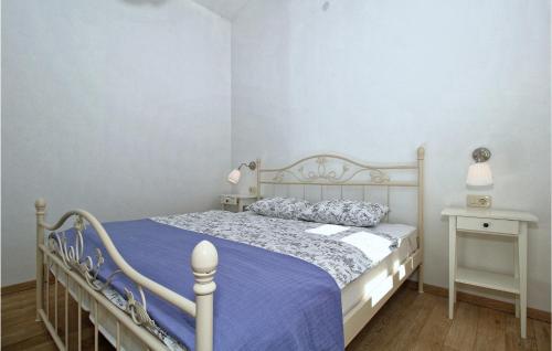 a bedroom with a white bed with a blue comforter at 6 Bedroom Cozy Home In Pazin in Brajkovići