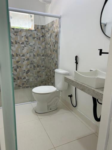 a bathroom with a toilet and a shower and a sink at Su House Suíte Arraial dAjuda in Porto Seguro