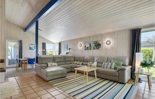 a living room with a couch and a table at Holiday Home Pøt Strandby Denm in Sønderby