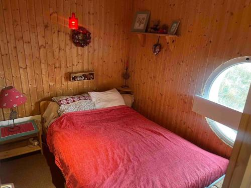 une chambre avec un lit avec une couverture rouge dans l'établissement Le Cocon de l'Alpes, à Huez