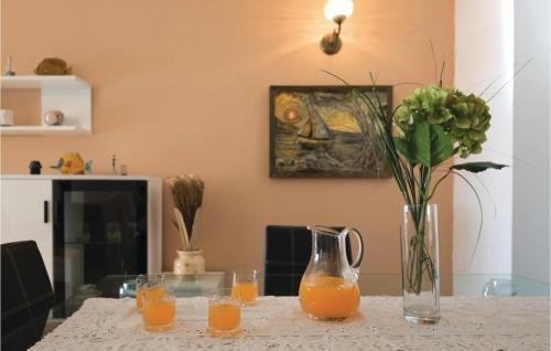 a table with a vase of orange juice and flowers at Two-Bedroom Apartment In Ploce in Ploče