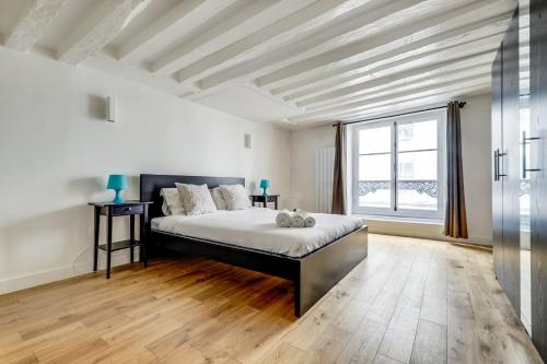 une chambre avec un lit et une grande fenêtre dans l'établissement Le Lotus - Spacious & Central - Opéra, à Paris