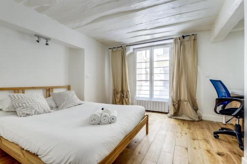 une chambre avec un lit, une chaise et une fenêtre dans l'établissement Le Lotus - Spacious & Central - Opéra, à Paris