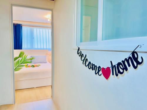 a bedroom with a bed and a sign that reads welcome home at Sadang Greennarae Stay in Seoul
