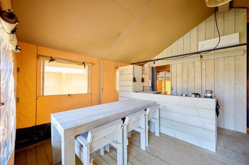 a kitchen with a long wooden table in a room at Glamping Borken in Borken
