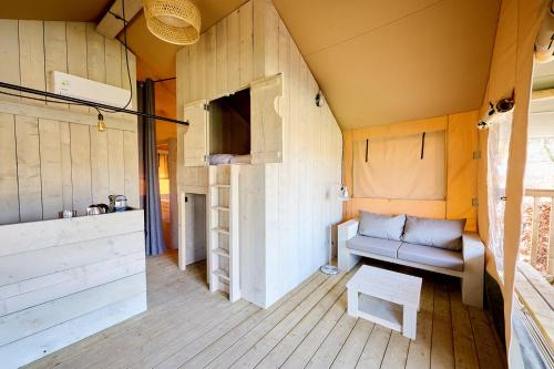 a room with a couch in a tiny house at Glamping Borken in Borken